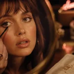 Maquillage année 70 : yeux irisés dorés, teint lumineux, gloss pêche