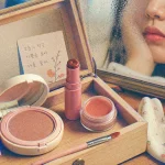Maquillage coréen glowy : produits K-beauty sur trousse en bois clair